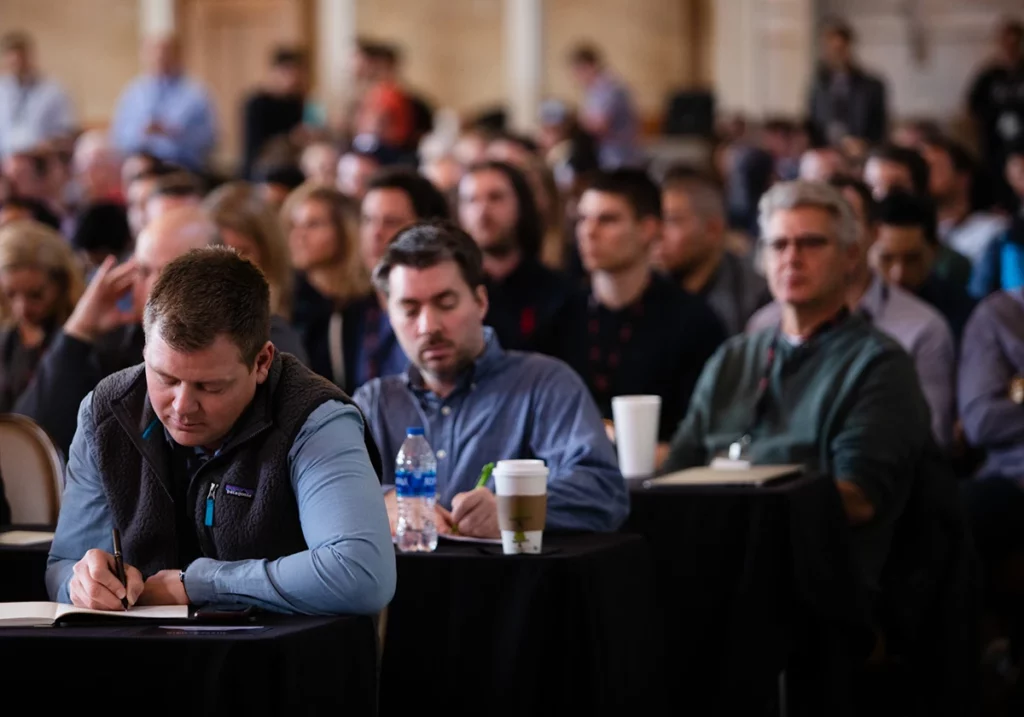 Attendee writing down notes